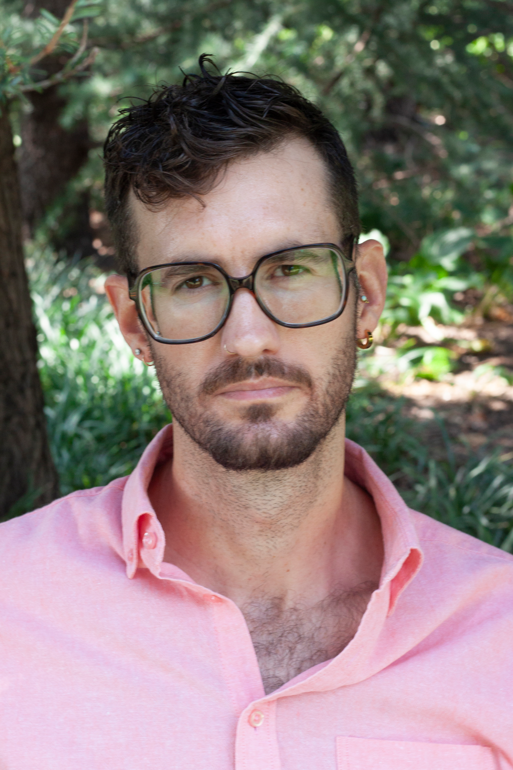 Christian Bancroft in a professional headshot wearing a pink button-up shirt.